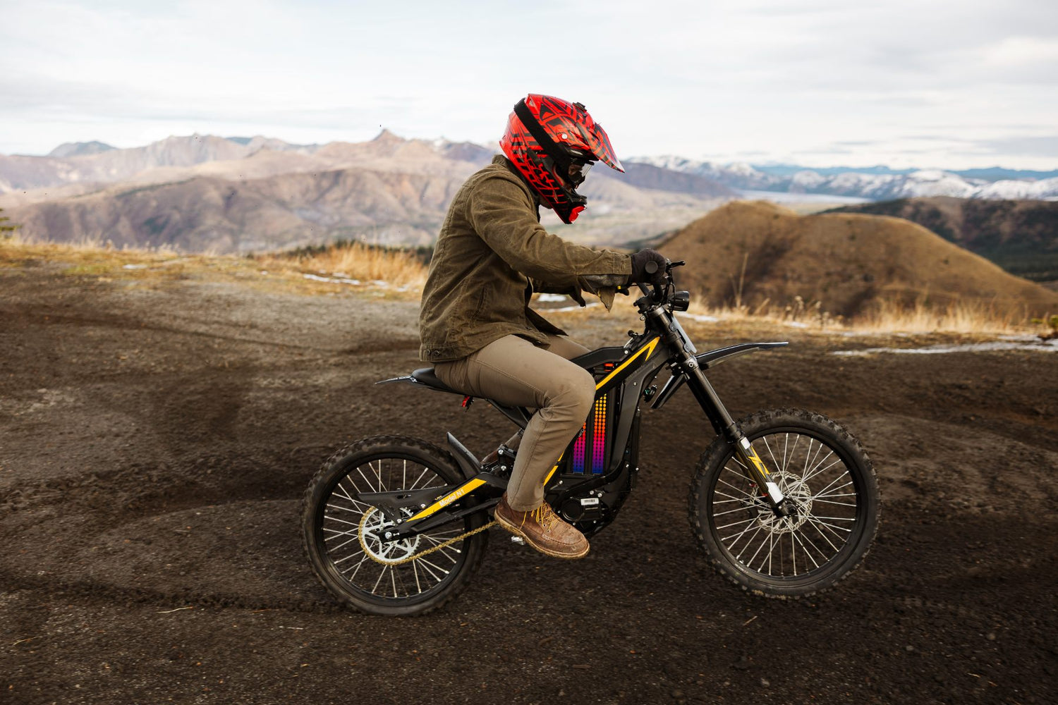 Person riding an freego N1 electric bike on a dirt path with mountains in the background
