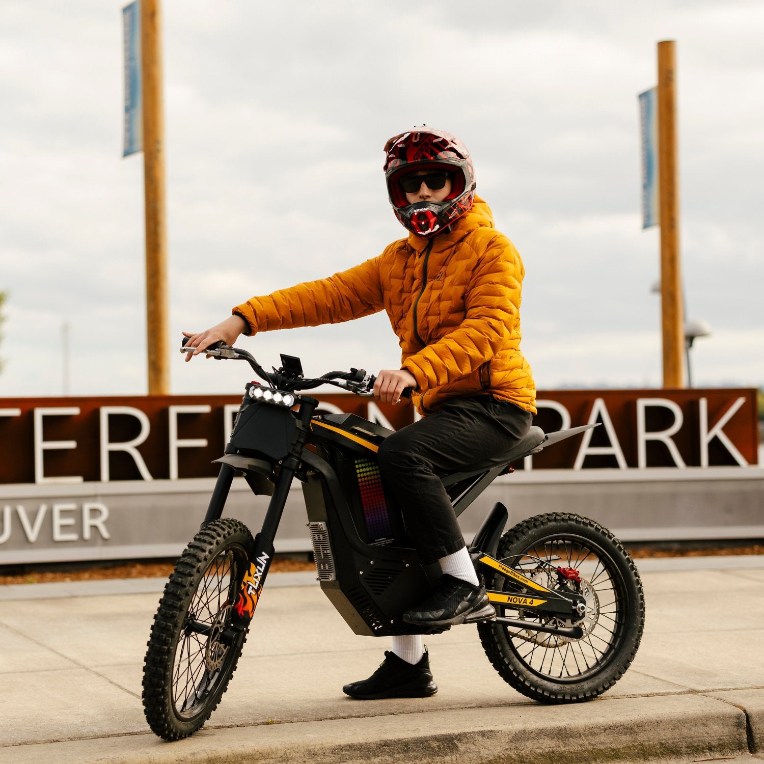 Freego Nova 4 electric dirt bike rider riding on urban street near park