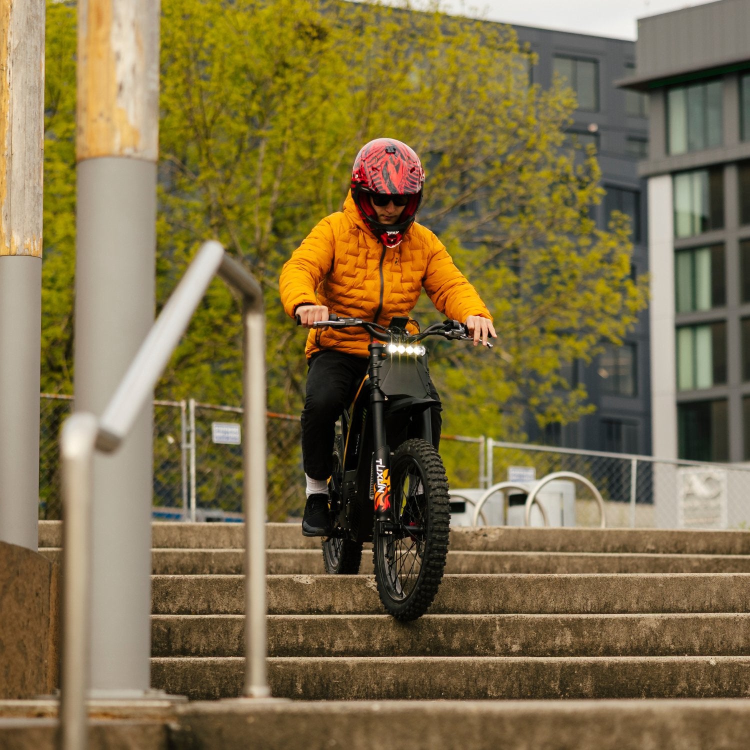Freego Nova 4 electric dirt bike riding down steps action in urban park