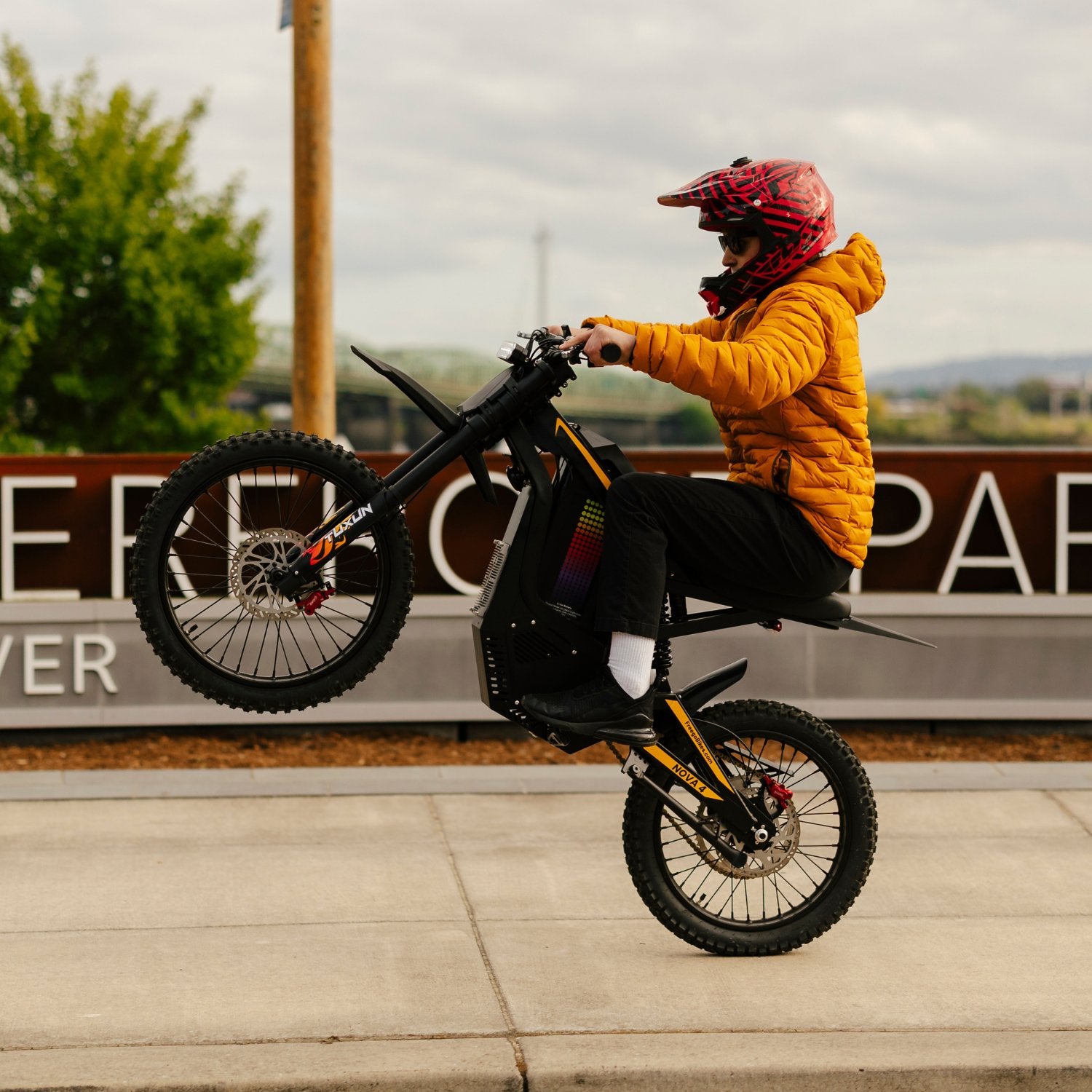 Freego Nova 4 electric dirt bike performing wheelie riding action on pavement