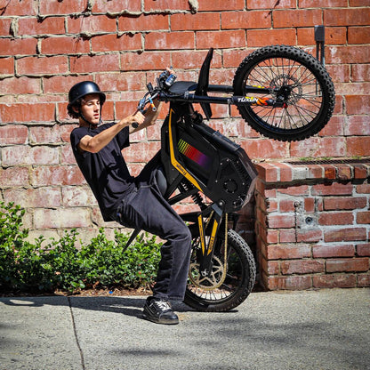 Freego Nova 4 electric bike wheelie action shot against brick wall