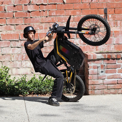 Freego Nova 4 electric bike wheelie action shot against brick wall
