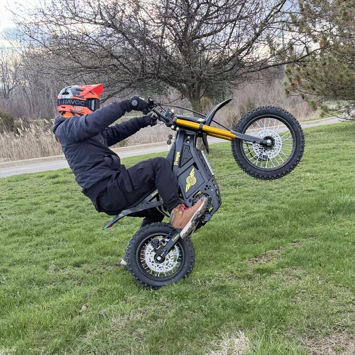 Freego Nova 5 mini electric bike wheelie action shot on grass, photo by runplayback