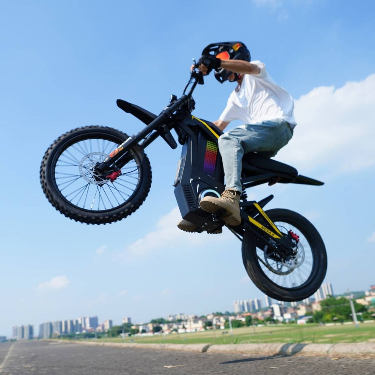 Rider performing a mid-air stunt on Freego Nova4 electric dirt bike with city skyline background