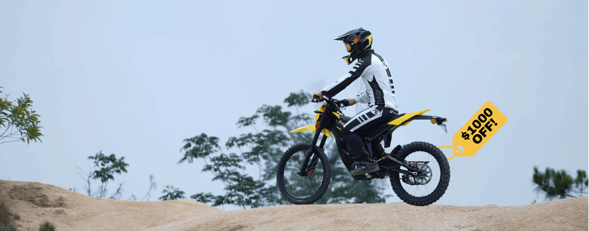 Person riding a Nova 5 dirt bike with a 'Sale' sign in the background