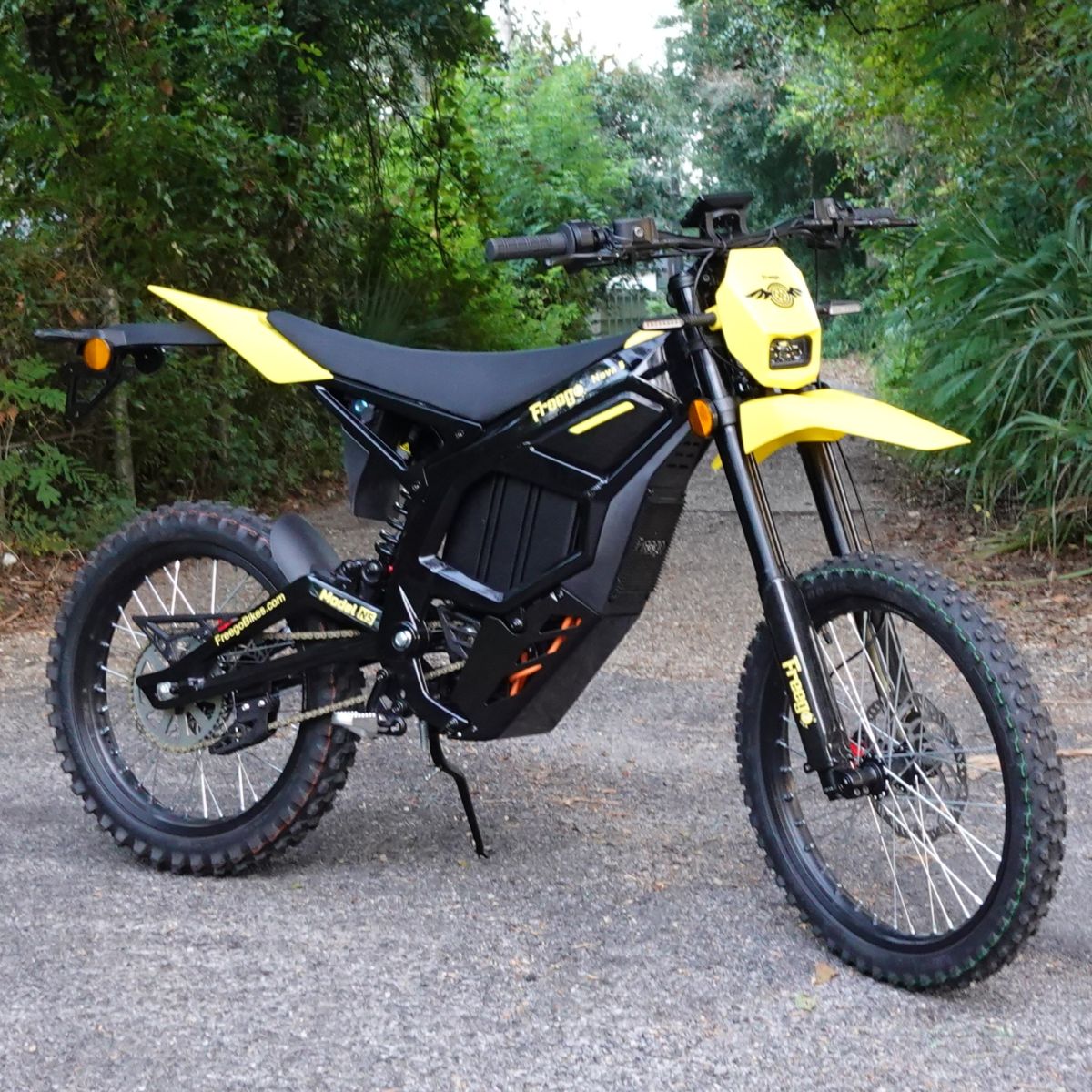 Black and yellow electric bike on a road with greenery in the background