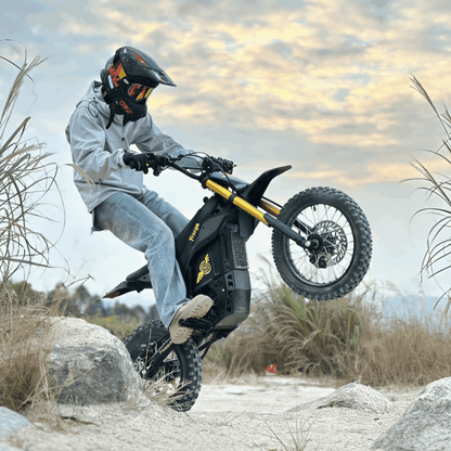Person riding a Nova 5 Mini electric bike in a natural setting with a cloudy sky.