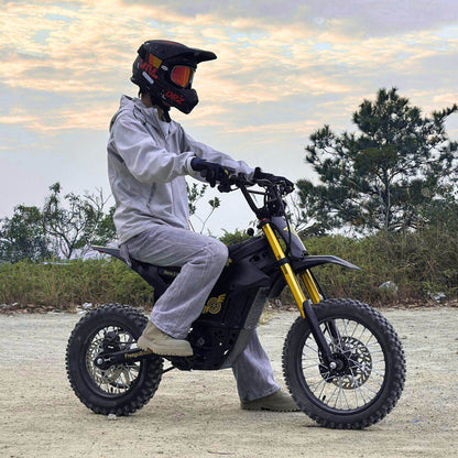 Person riding a Nova 5 Mini ebike with yellow suspension forks in an outdoor setting.