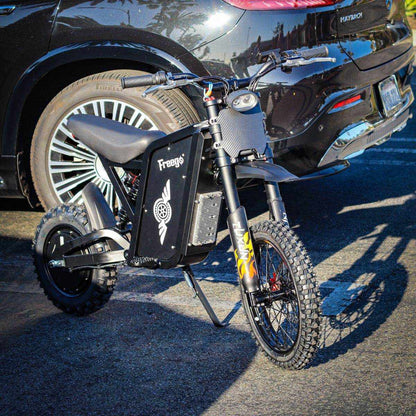 A freego X0 Mini ebike parked next to a car on a street.