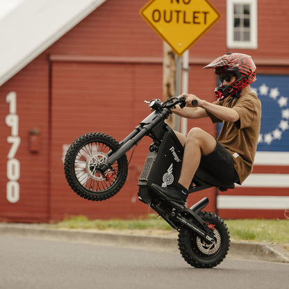 Rider performing a wheelie on a Freego X0 on a city street, showcasing agile handling and powerful off-road performance.