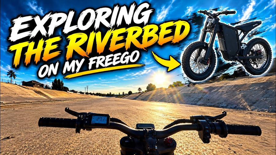 Freego electric dirt bike riding through city and small-town roads on the way to a sandy riverbed for off-road riding.