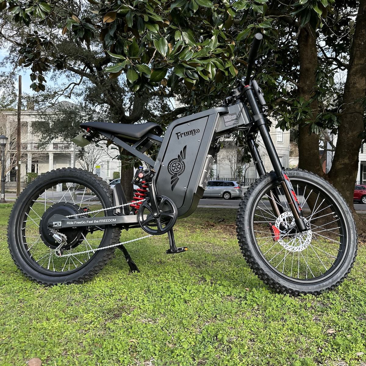 Freego X2 dirt ebike parked on grass under trees