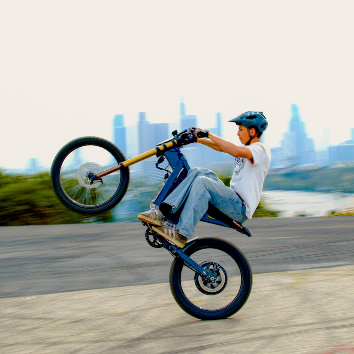 Person riding a X2 Pro dirt bike with a cityscape in the background