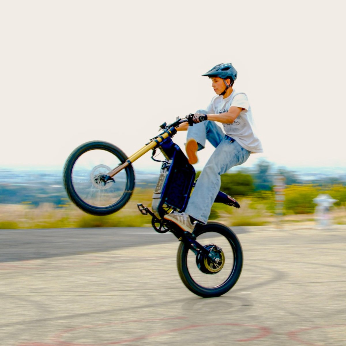 Person riding a X2 Pro dirt bike with one wheel off the ground on a blurred background