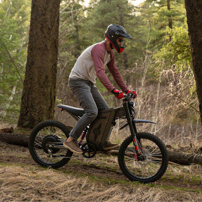 Person riding a Freego X2 Pro dirt ebike in a forest setting