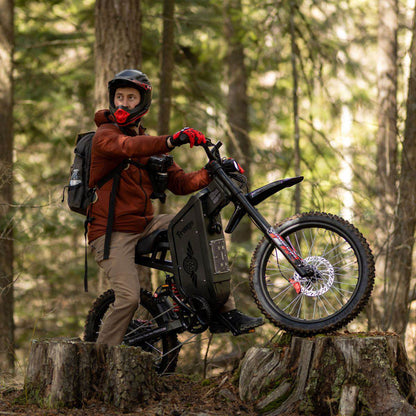 Person with a Freego X2 Pro dirt ebike in a forest setting
