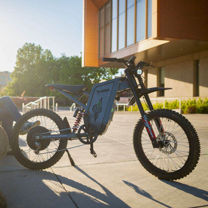 A Freego X2 Pro dirt ebike parked on a sidewalk with a modern building in the background