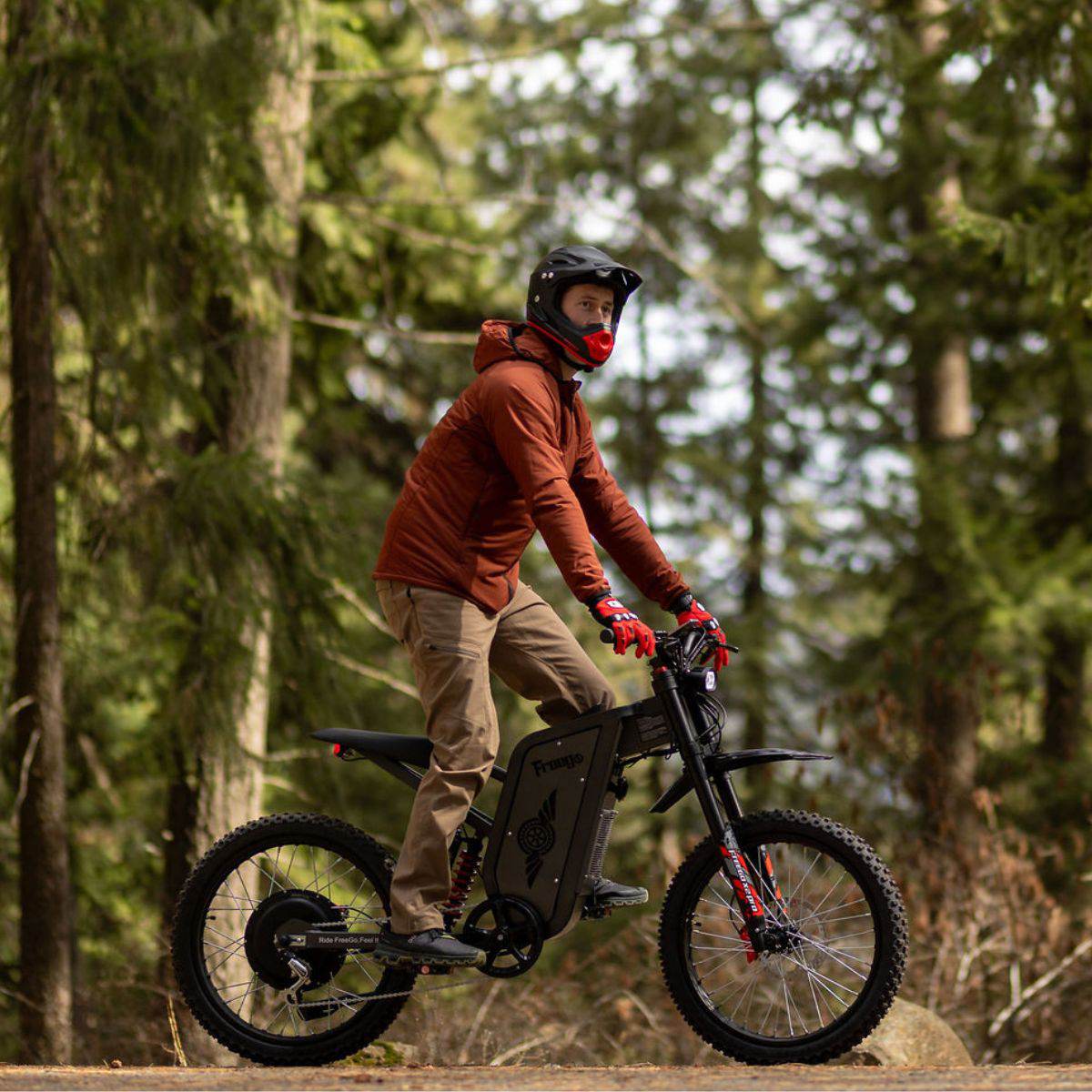 Person riding an Freego X2 Pro dirt ebike in a forest setting