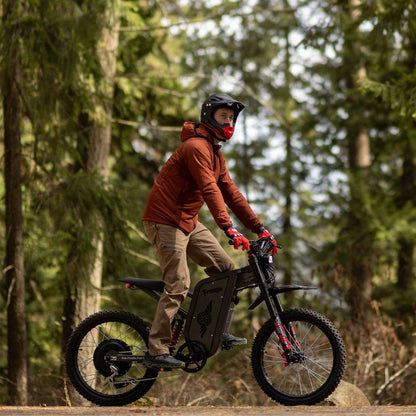 Person riding an Freego X2 Pro dirt ebike in a forest setting