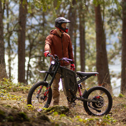 Person with a Freego X2 Pro dirt ebike in a forest setting
