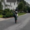 Outdoor action shot of TikTok creator x2.will riding Freego electric bike with wheelie stunt on residential suburban street