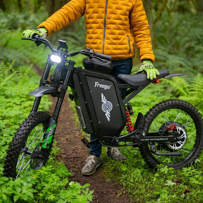 Rider on the Freego X3 Pro electric dirt bike riding through a forest trail.