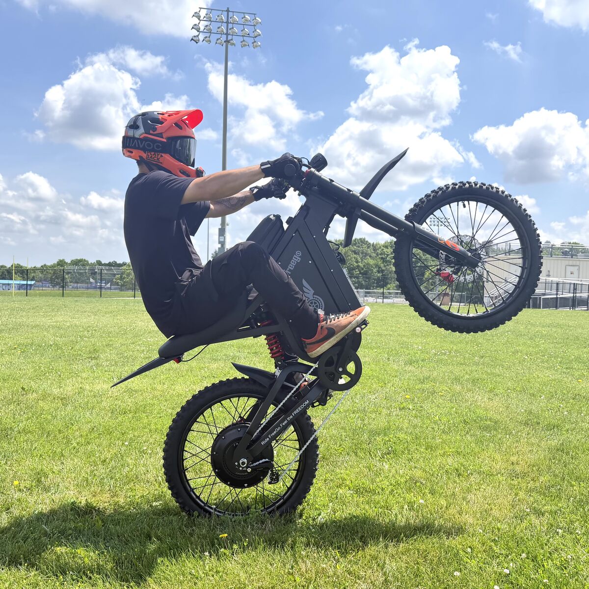 RunPlayBack wheelie stunt riding Freego X3 Pro ebike, outdoor grass field action shot
