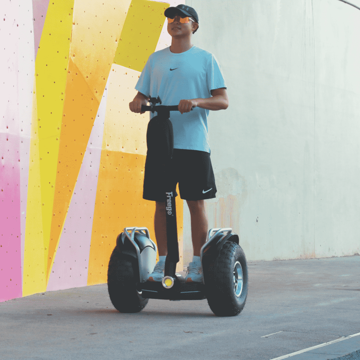 Person riding a hoverboard against a colorful wall.