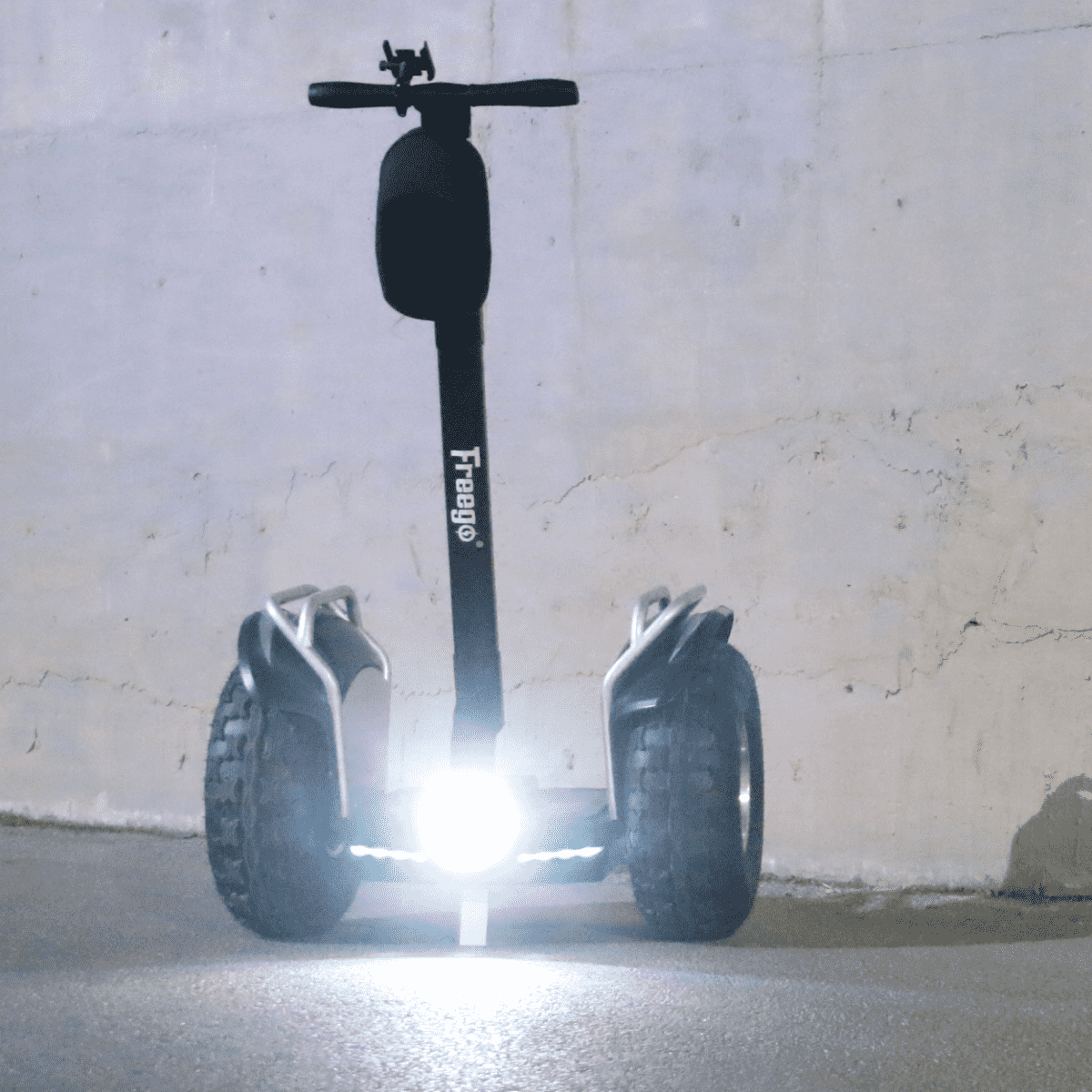 Black Segway-like scooter on a concrete floor with a light gray wall background