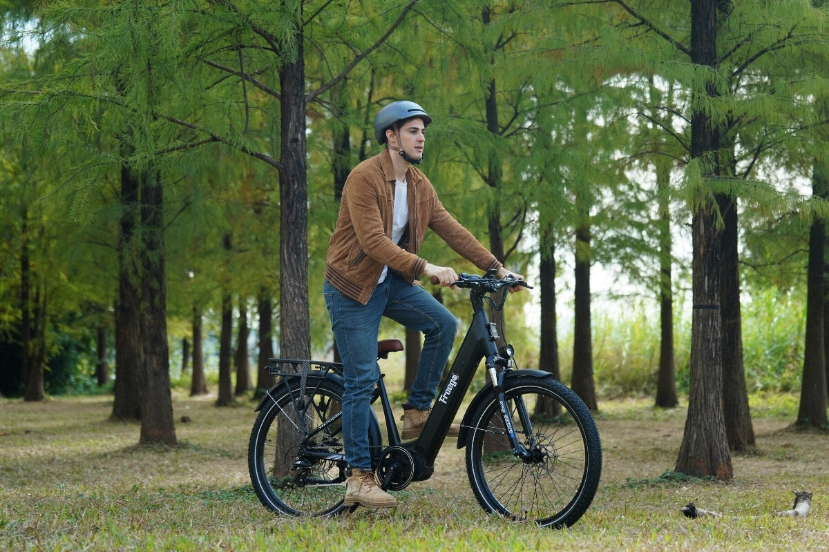 Man riding an electric bike in a park with trees in the background