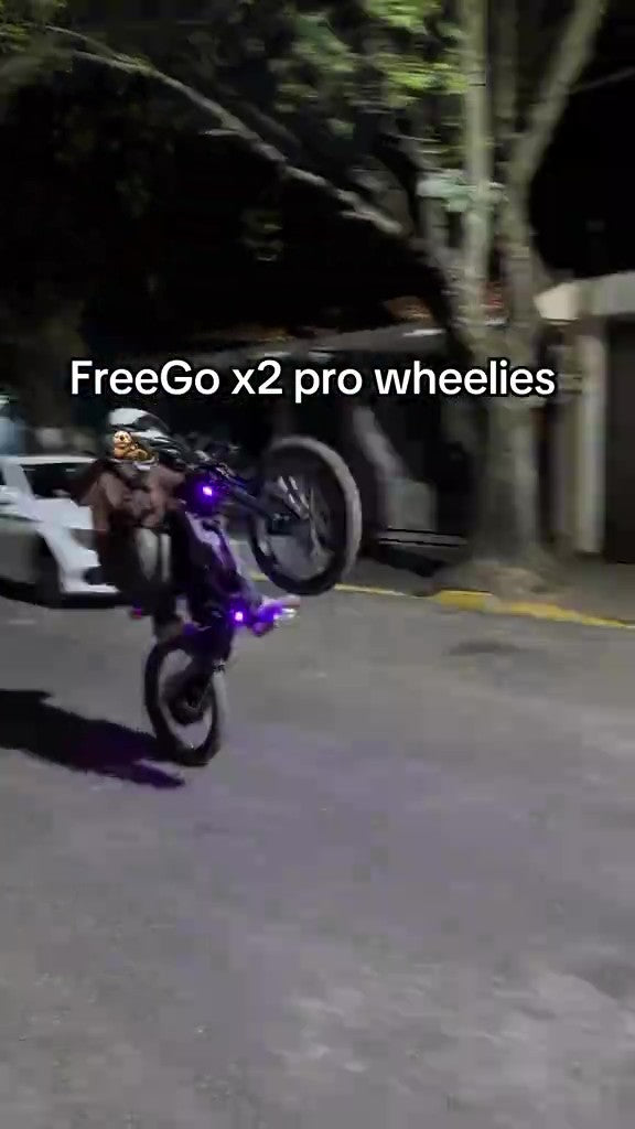 Motorcycle performing a wheelie on a street with 'FreeGo x2 pro wheelies' text.
