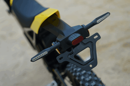 Close-up of a motorcycle's license plate holder with a blurred background