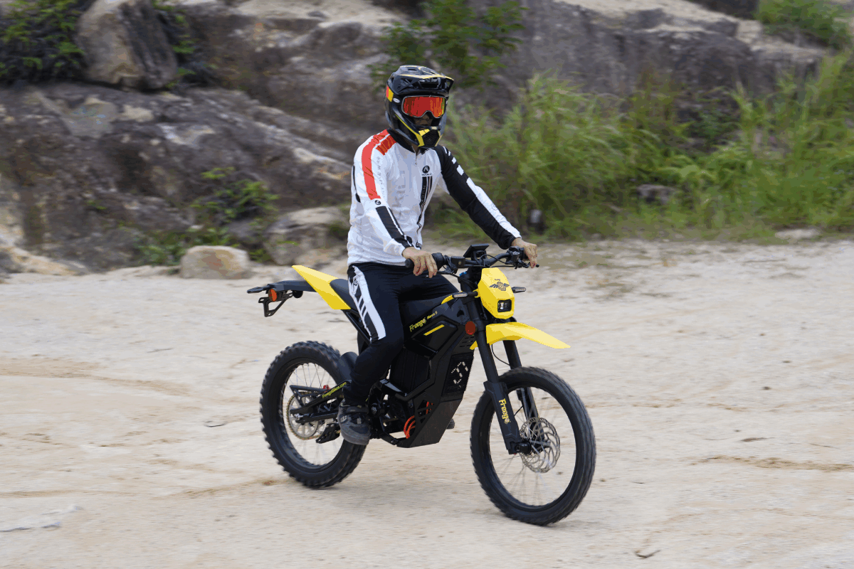 Person riding a yellow electric bike on a rocky terrain